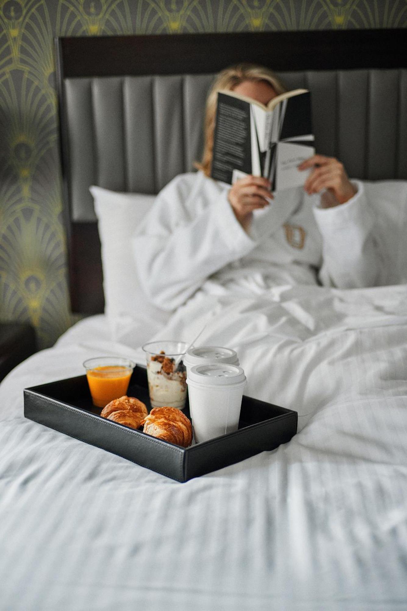 Hotel Edison Times Square New York Exterior photo A woman reading a book while lying in bed.